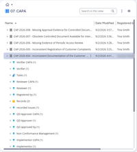 Ett annat exempel: CAPA-listan i M-Files med CAP-2026-004 utfälld till allt som är kopplat till den: dess uppgifter, två poster, det registrerade ärendet och non conformance-posten bakom, och personerna i varje roll, från QD-godkännare och genomförare till granskare, verifierare och den som registrerade den. CAP-2026-005 till CAP-2026-008 listas ovanför.